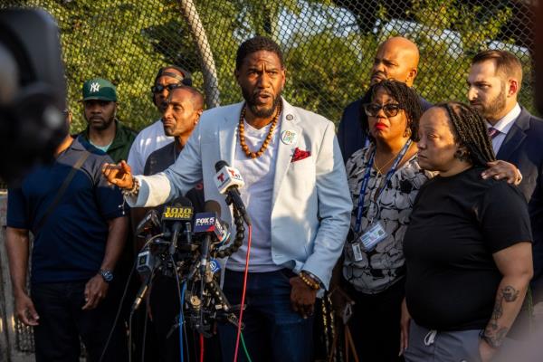 Jumaane Williams, NYC Public Advocate, speaking at a press conference in Brooklyn following the release of NYPD bodycam footage of subway shooting, surrounded by microphones and people.